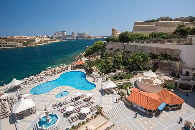 Het buitenzwembad en uitzicht op de haven van het Grand Hotel Excelsior Malta.